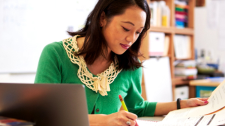 Woman at desk using laptop.